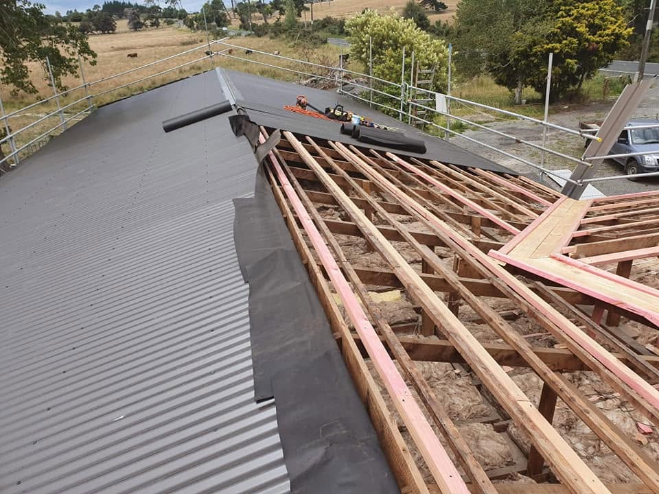 Re-roofing underway with membrane, battens and long-run sheets on a house